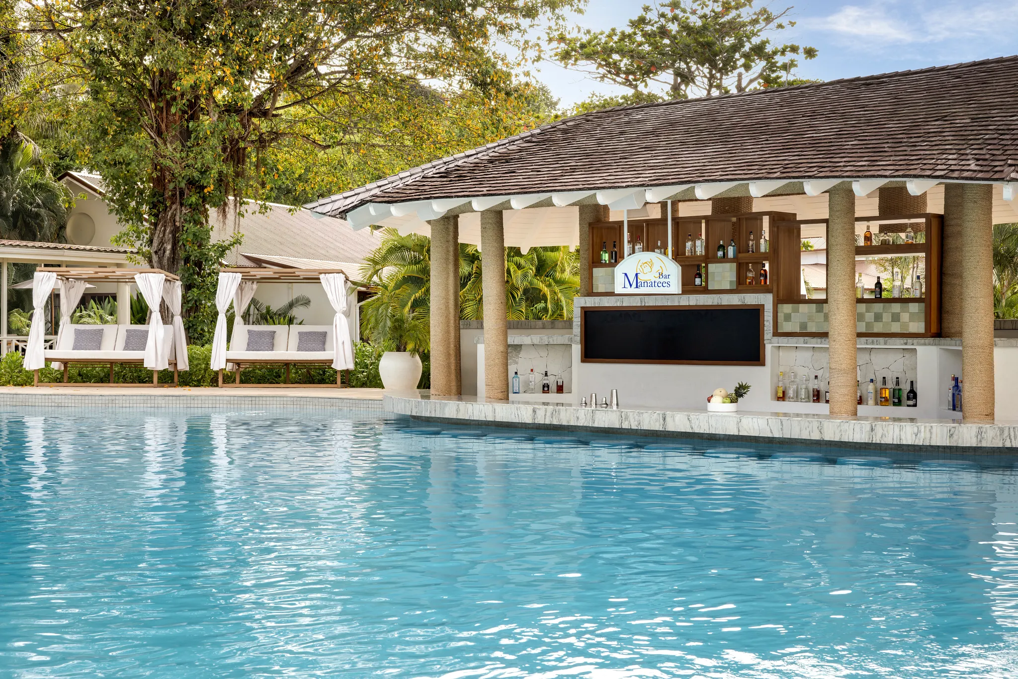 Swim-up bar at Secrets St. Lucia Resort & Spa with cabanas and tropical surroundings.