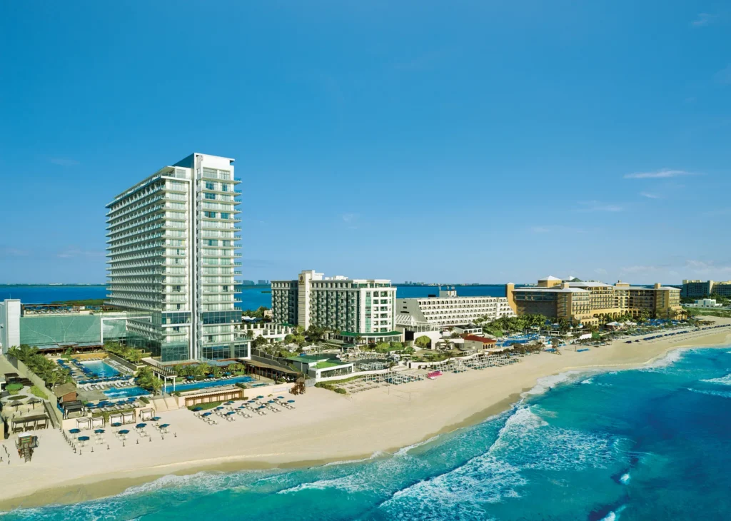 Aerial view of Secrets The Vine Cancun beachfront resort with pools and white sand beach along the Caribbean Sea.