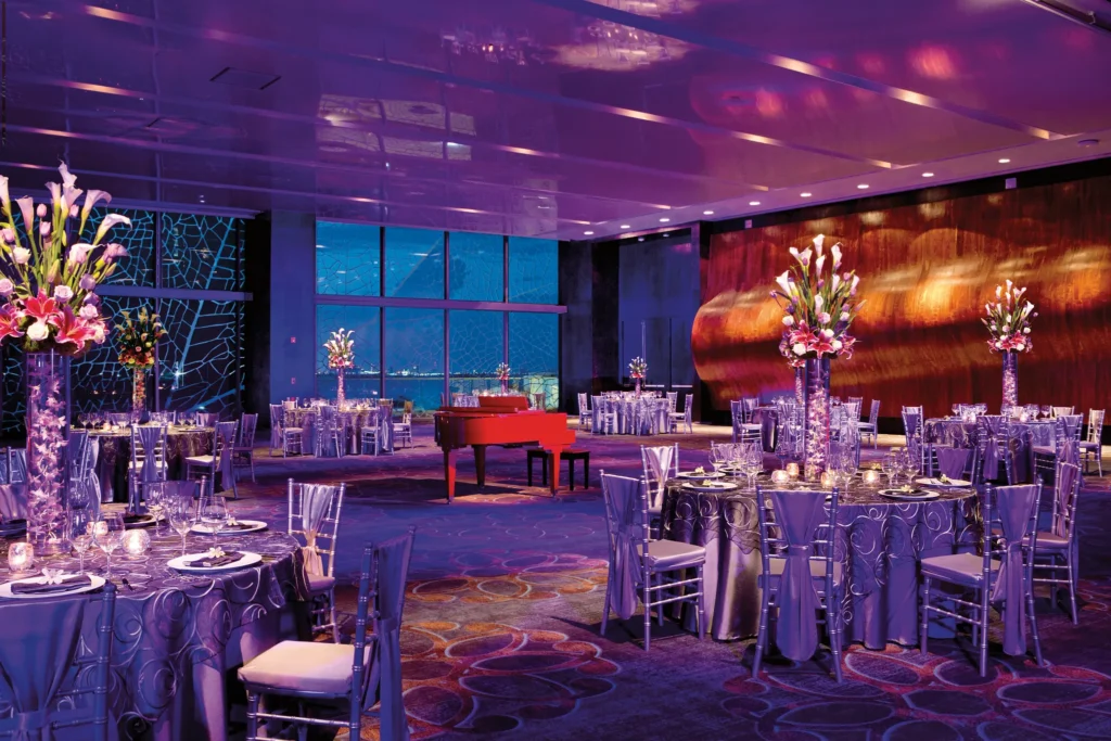 Elegant ballroom wedding reception setup with floral centerpieces at Secrets The Vine Cancun