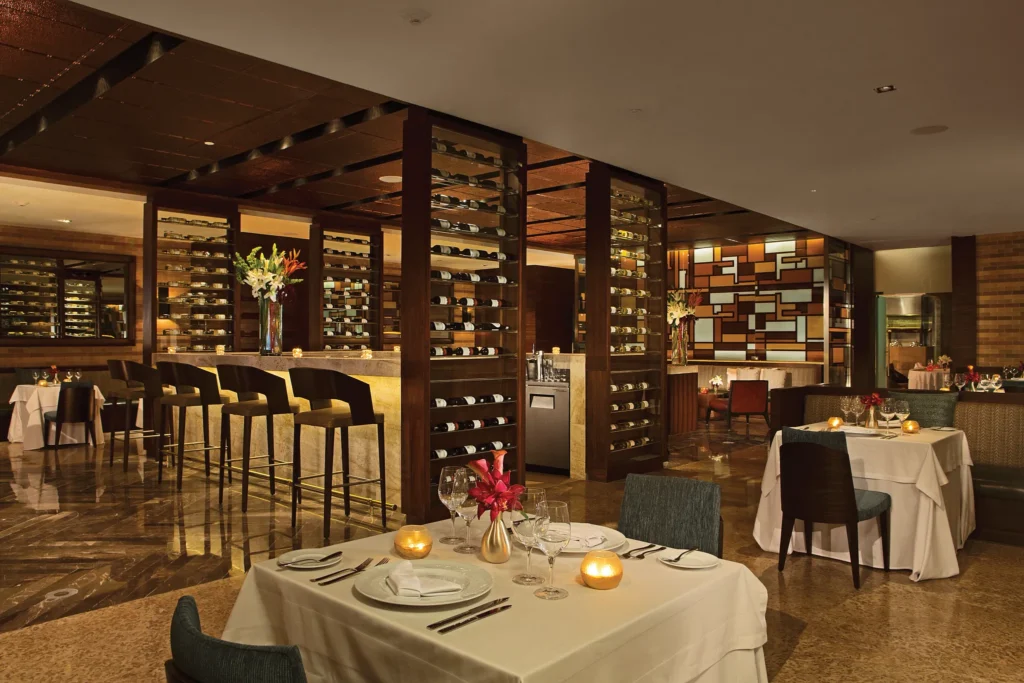 Bluewater Grill at Secrets The Vine Cancun featuring an elegant indoor and outdoor dining setting with premium steaks and grilled specialties.