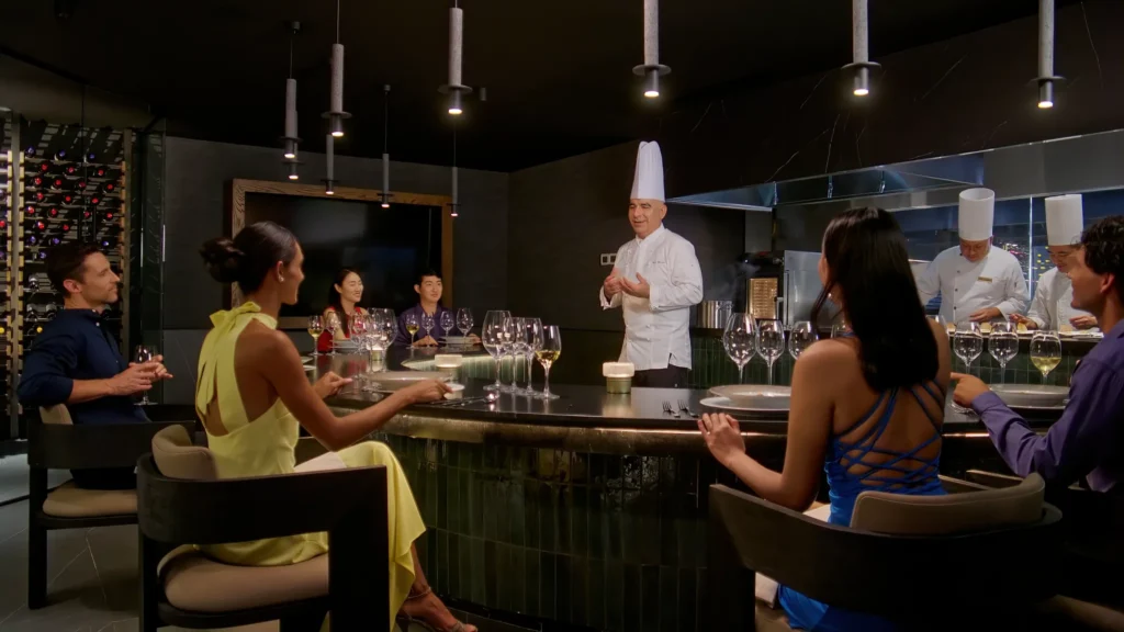 Guests enjoying a chef-led dining experience at an interactive restaurant at Secrets The Vine Cancun.