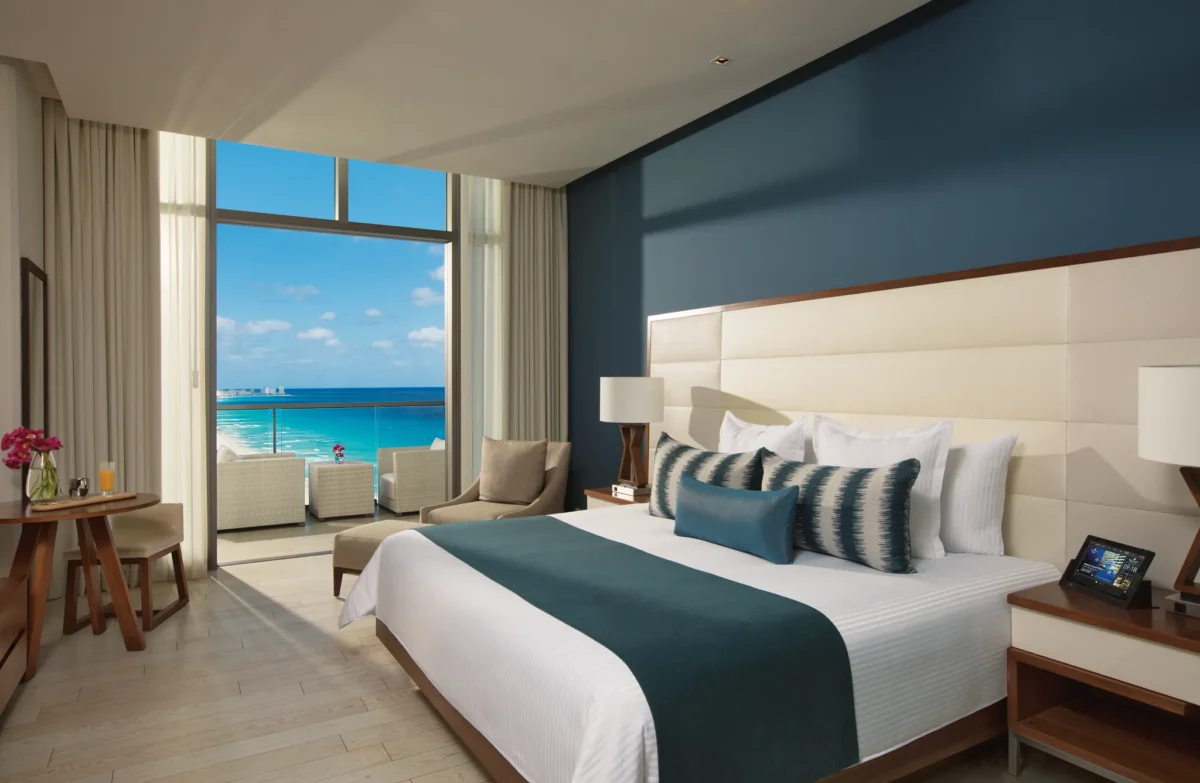 Deluxe Partial Ocean View room with king bed and private balcony overlooking the Caribbean at Secrets The Vine Cancun.