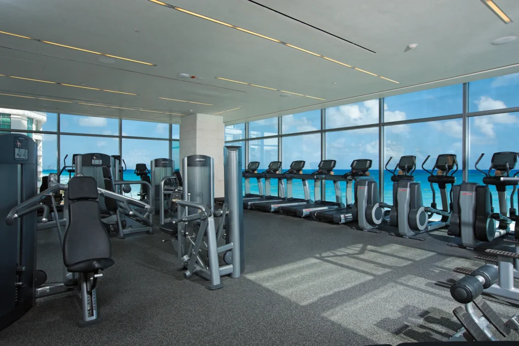 Modern fitness center with strength equipment and ocean views at Secrets The Vine Cancun.