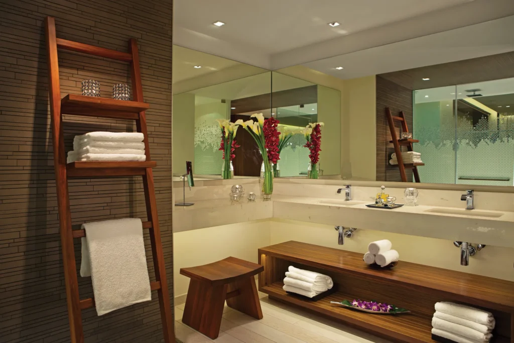 Junior Suite Ocean View bathroom with double vanity and glass-enclosed shower at Secrets The Vine Cancun.
