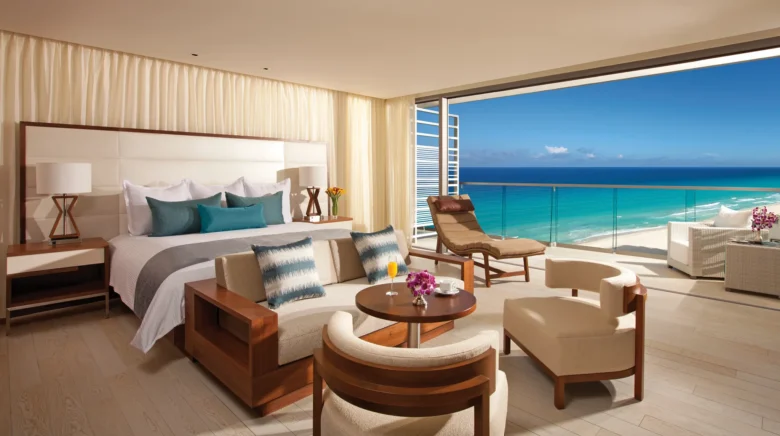 Junior Suite Ocean View with king bed, sitting area, and oceanfront balcony at Secrets The Vine Cancun.