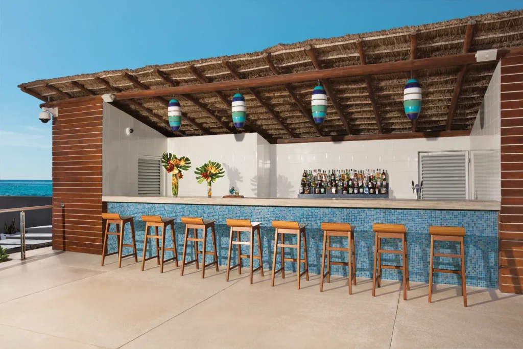 Manatees Poolside Bar at Secrets The Vine Cancun featuring a relaxed poolside setting with tropical drinks, beers, and ocean views.