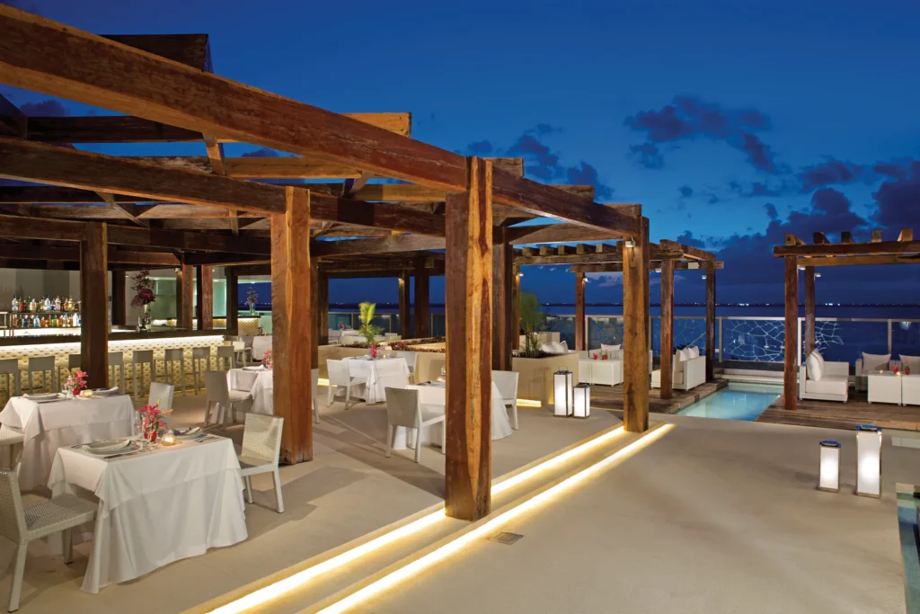 Olio Mediterranean Restaurant at Secrets The Vine Cancun featuring a stylish dining setting with lagoon views and Mediterranean-inspired dishes.