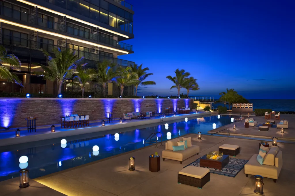 Poolside terrace evening reception setup with lounge seating at Secrets The Vine Cancun