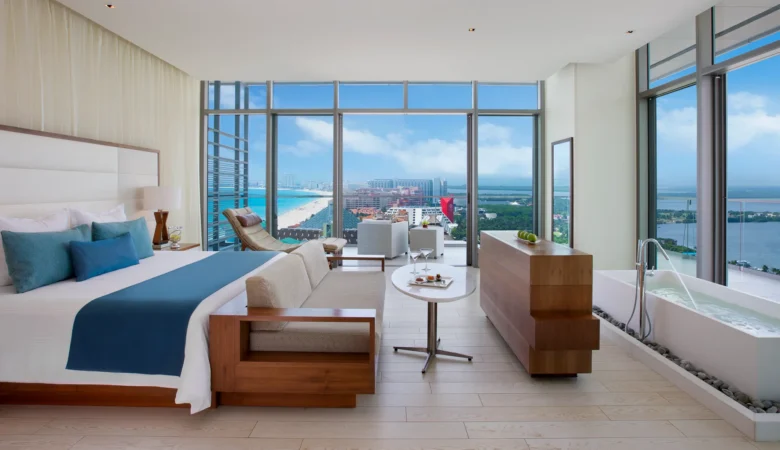 Preferred Club Honeymoon Suite Ocean View with king bed, sitting area, soaking tub, and balcony at Secrets The Vine Cancun.