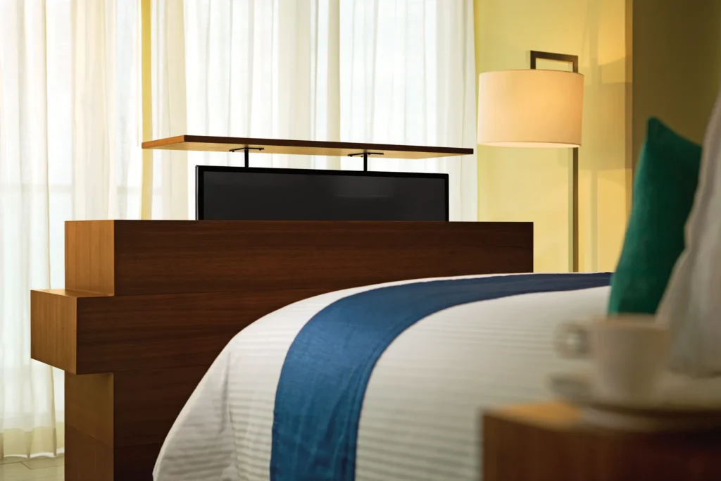 Preferred Club Honeymoon Suite Oceanfront with motorized TV and modern wood furnishings at Secrets The Vine Cancun.