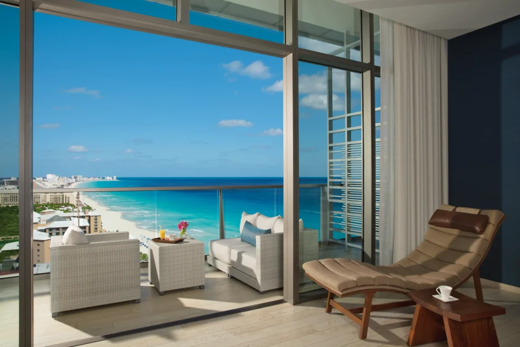 Preferred Club Junior Suite Ocean View private balcony with seating and ocean views at Secrets The Vine Cancun.