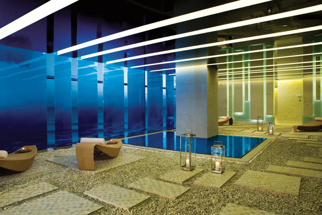 Spa relaxation area with indoor pool and ambient lighting at Secrets The Vine Cancun.