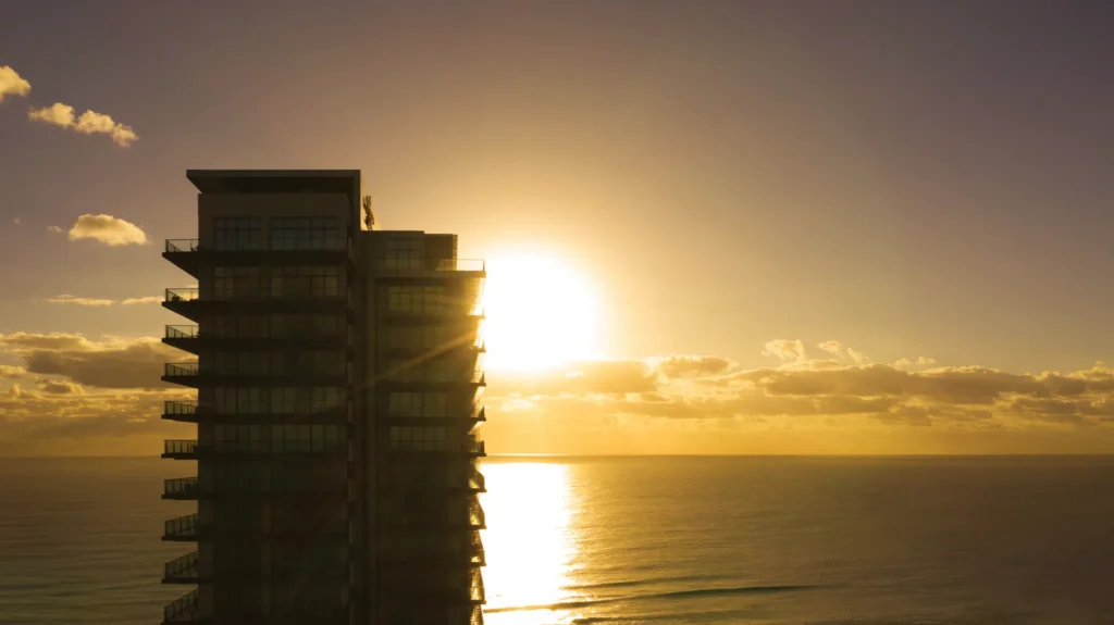 Secrets The Vine Cancun resort building during golden hour with ocean views in the background.