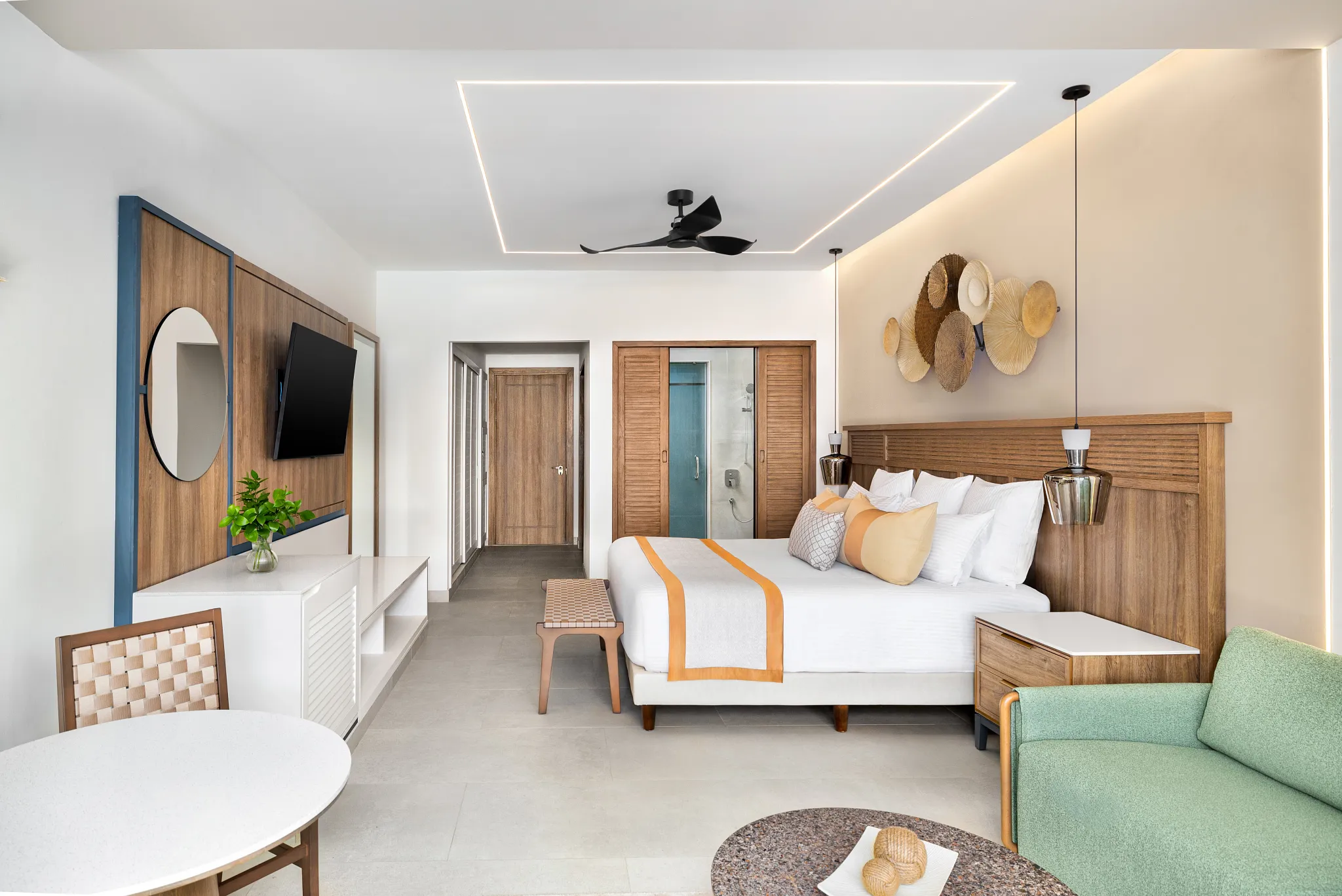 Junior Suite with king bed, modern wood accents, and seating area at Secrets Tides Punta Cana with tropical-inspired décor.