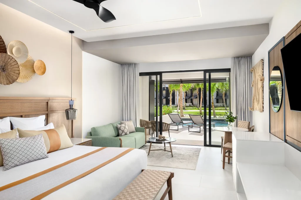 Junior Suite Swim-Out with king bed, seating area, and terrace leading to swim-up pool at Secrets Tides Punta Cana.