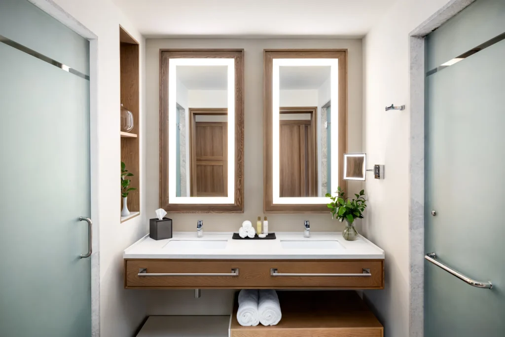 Preferred Club Junior Suite Ocean Front bathroom with double vanity and illuminated mirrors at Secrets Tides Punta Cana.