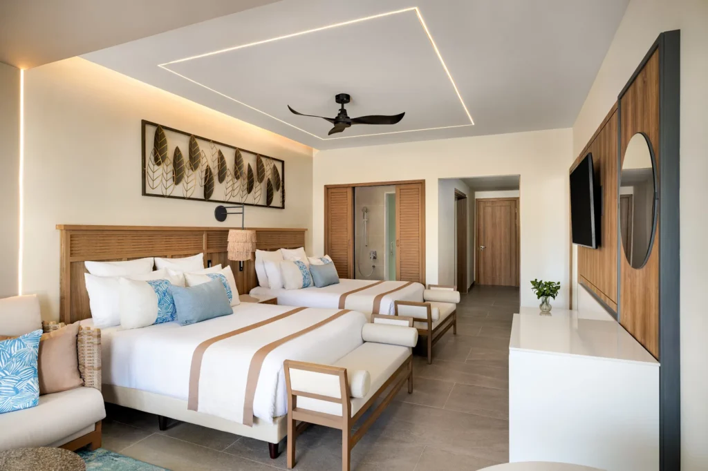 Preferred Club Junior Suite Ocean Front with two double beds and seating area at Secrets Tides Punta Cana.