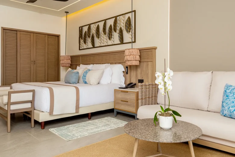 Preferred Club Junior Suite Partial Ocean with king bed and seating area at Secrets Tides Punta Cana resort.