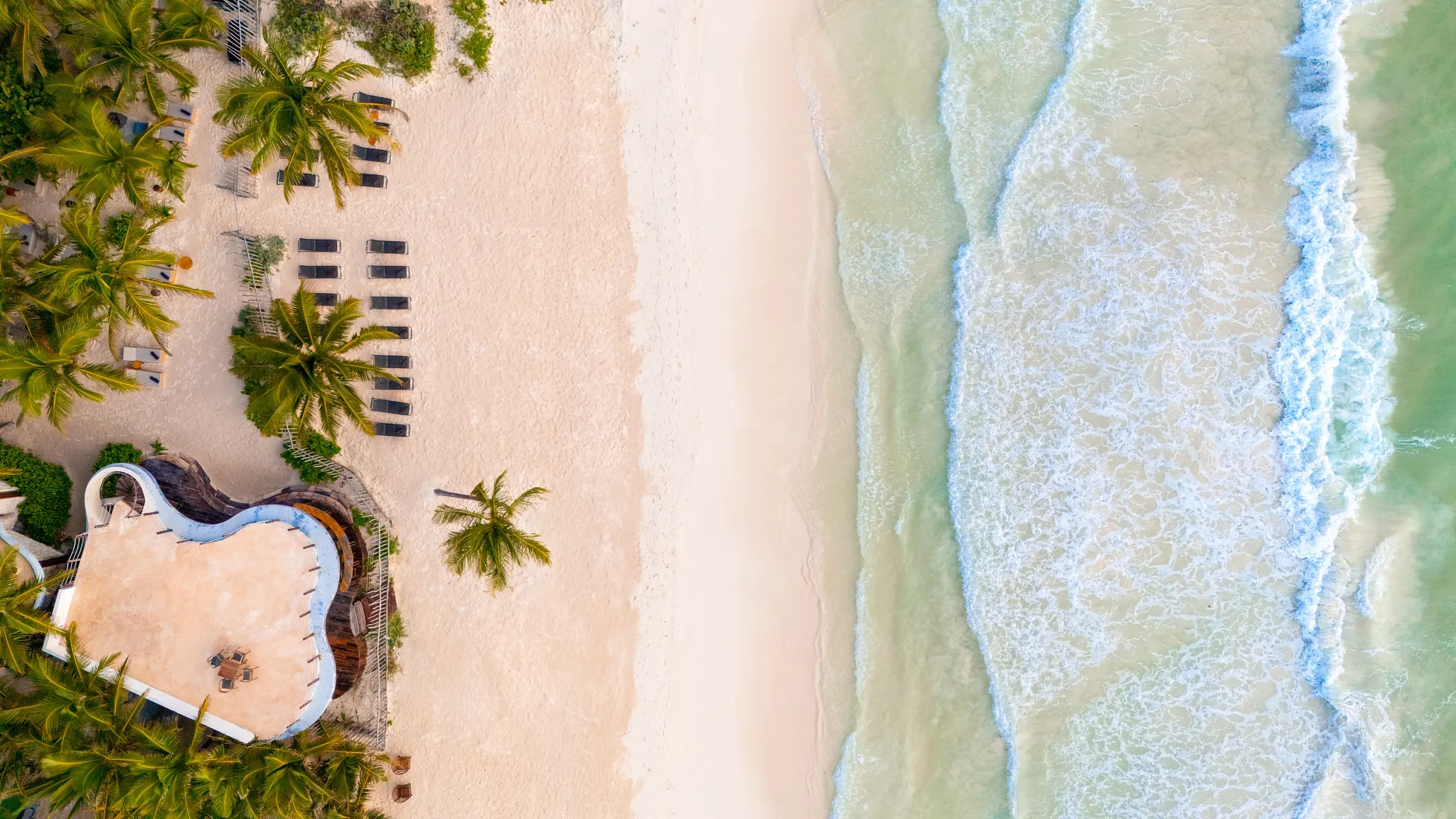Aerial view of the white-sand beach and turquoise Caribbean Sea at Casa Zamna Beach Club.