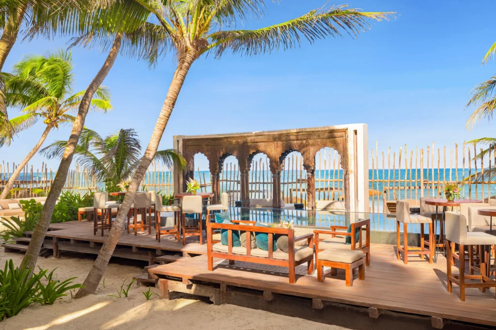 Elegant beachfront pool and lounge area at Casa Zamna Beach Club, part of Secrets Tulum Resort & Beach Club.