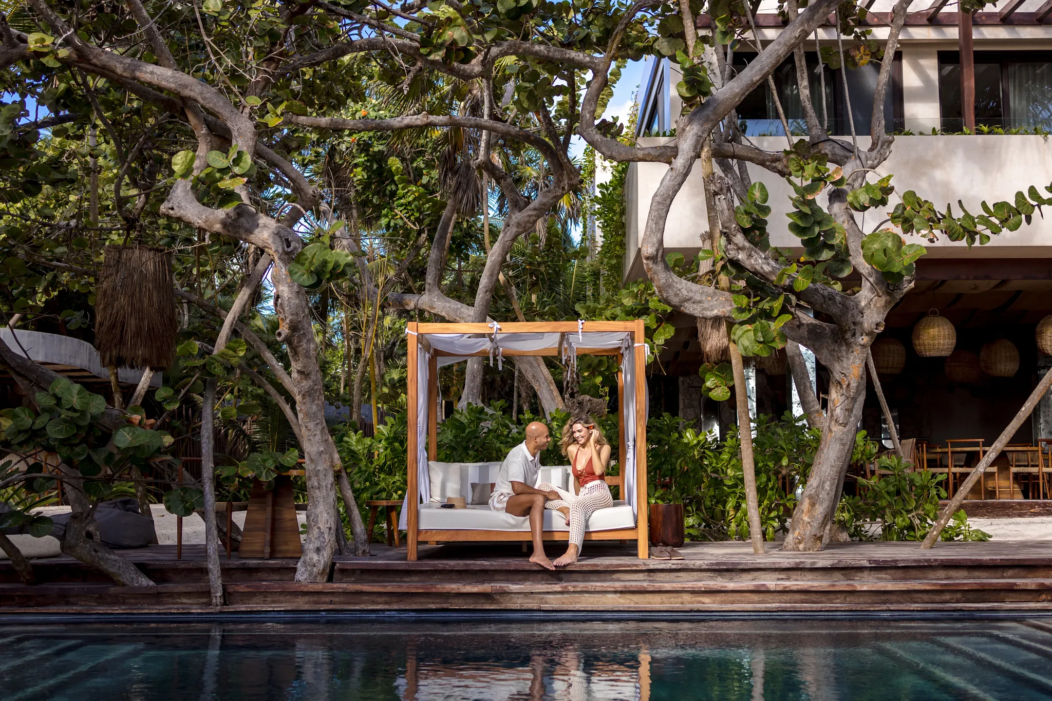 Couple relaxing together at Casa Zamna Beach Club at Secrets Tulum Resort & Beach Club overlooking the Caribbean Sea.