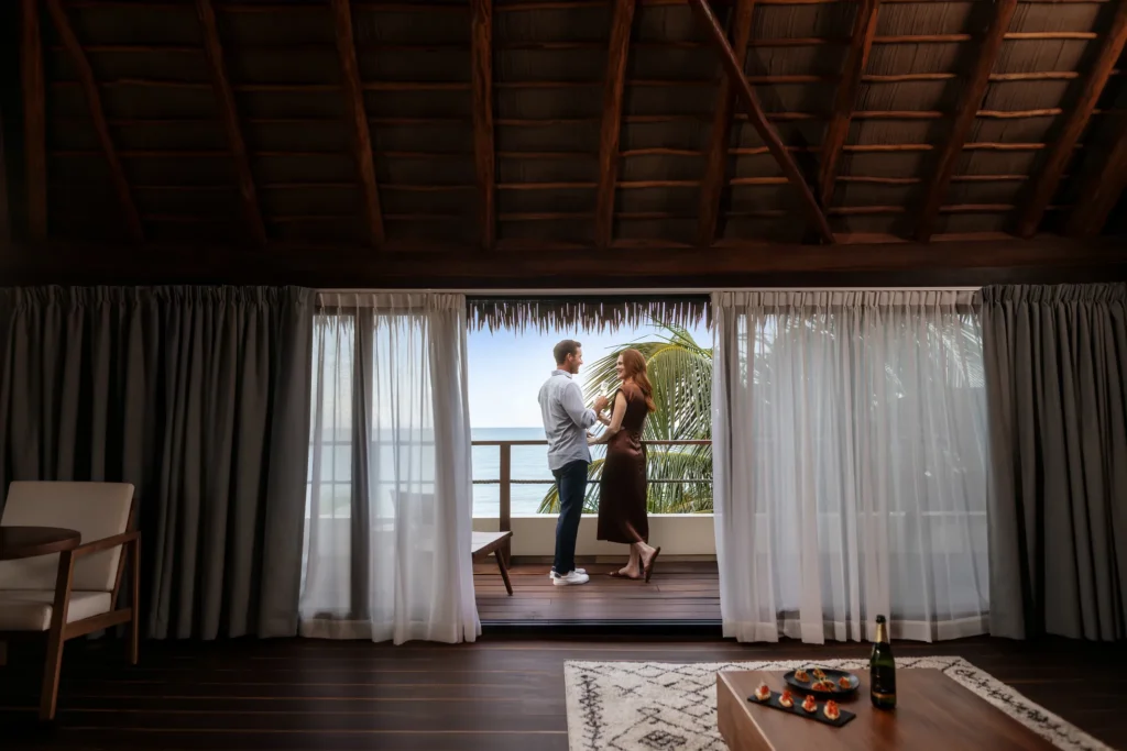 Couple enjoying an ocean-view balcony at Casa Zamna Beach Club in Tulum.