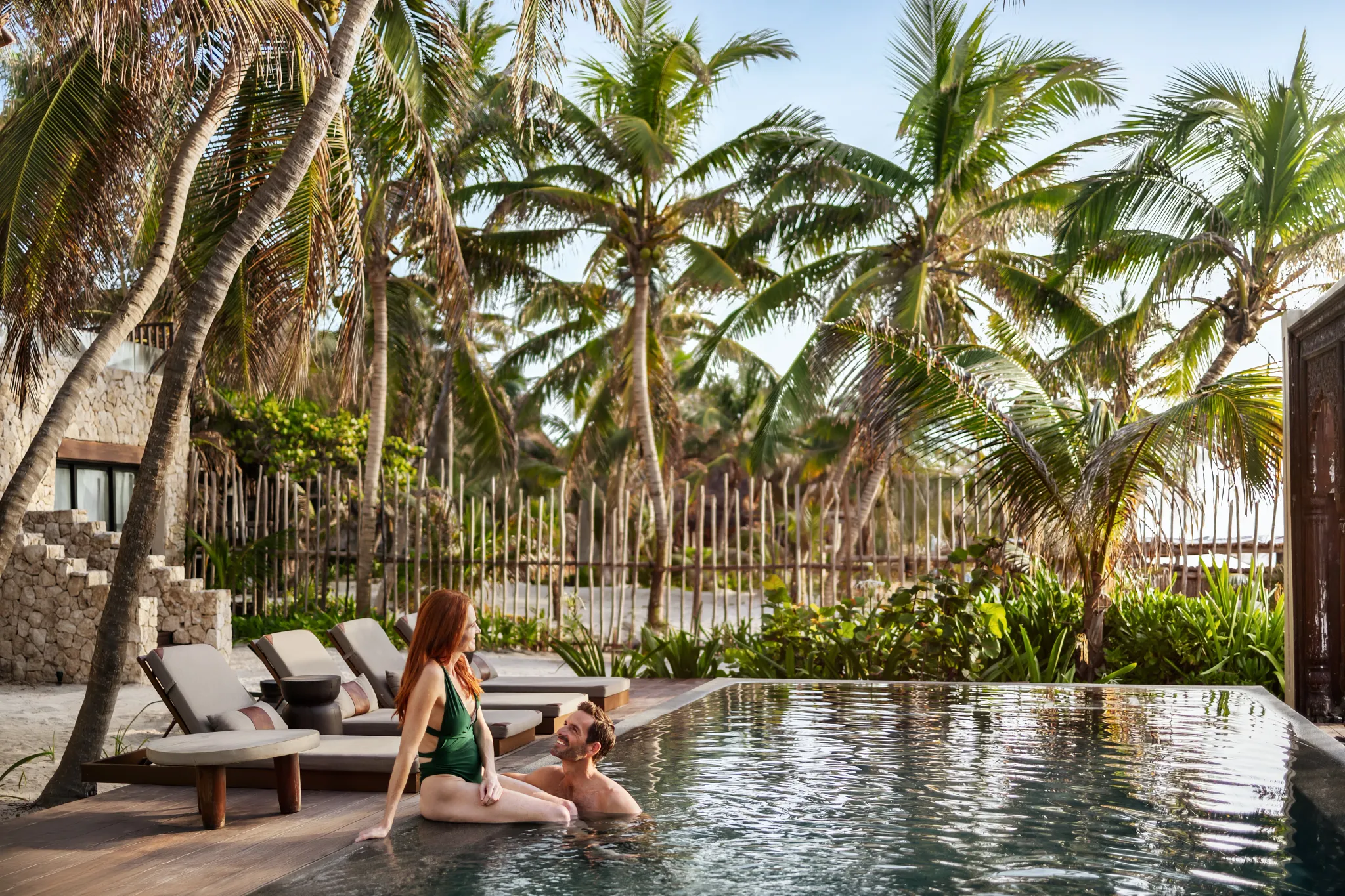 Couple relaxing in a private pool surrounded by tropical palms at Secrets Tulum Resort & Beach Club.