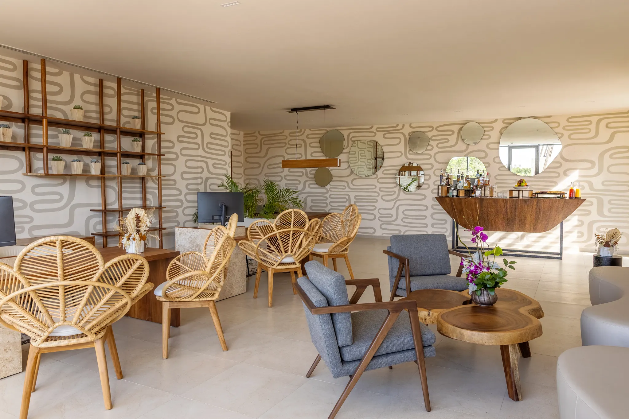 Modern spa reception lounge with rattan seating at the Secrets Spa by Pevonia® at Secrets Tulum Resort & Beach Club.