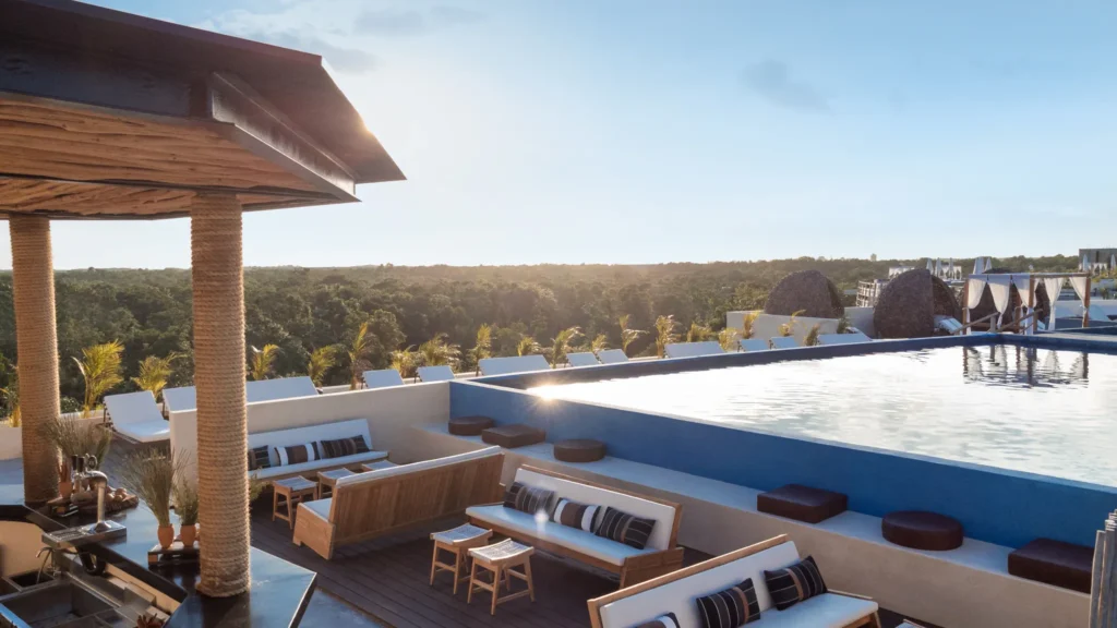 Rooftop infinity pool with lounge seating and panoramic jungle views at Secrets Tulum Resort & Beach Club.