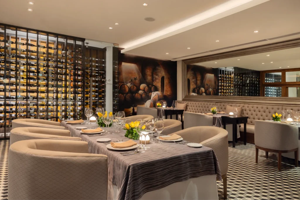 Elegant dining area and wine cellar at Capers Italian restaurant near Secrets Vallarta Bay Puerto Vallarta featuring upscale seating, candlelit tables, and extensive wine selection.