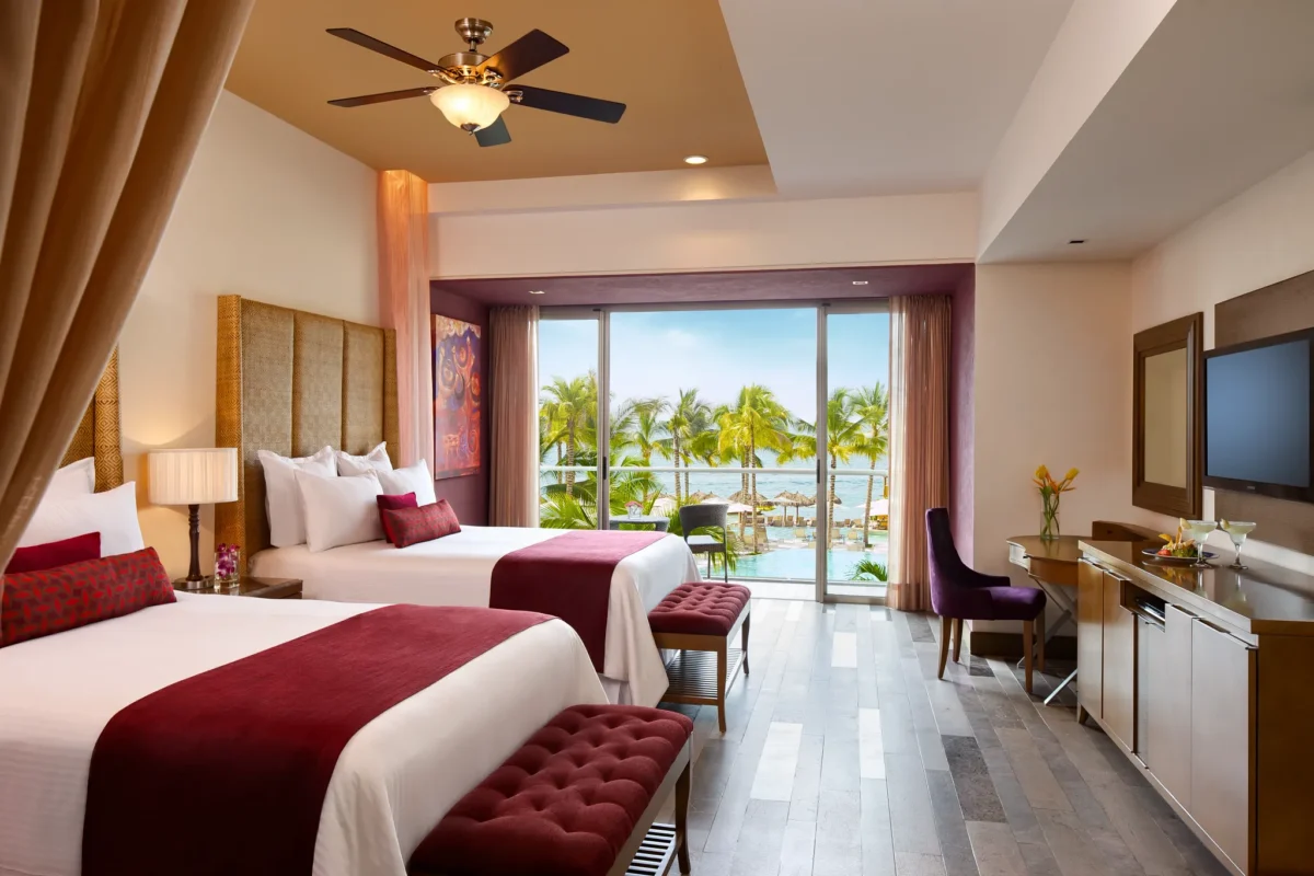 Junior Suite Garden View with two double beds and private balcony overlooking tropical gardens at Secrets Vallarta Bay Puerto Vallarta.