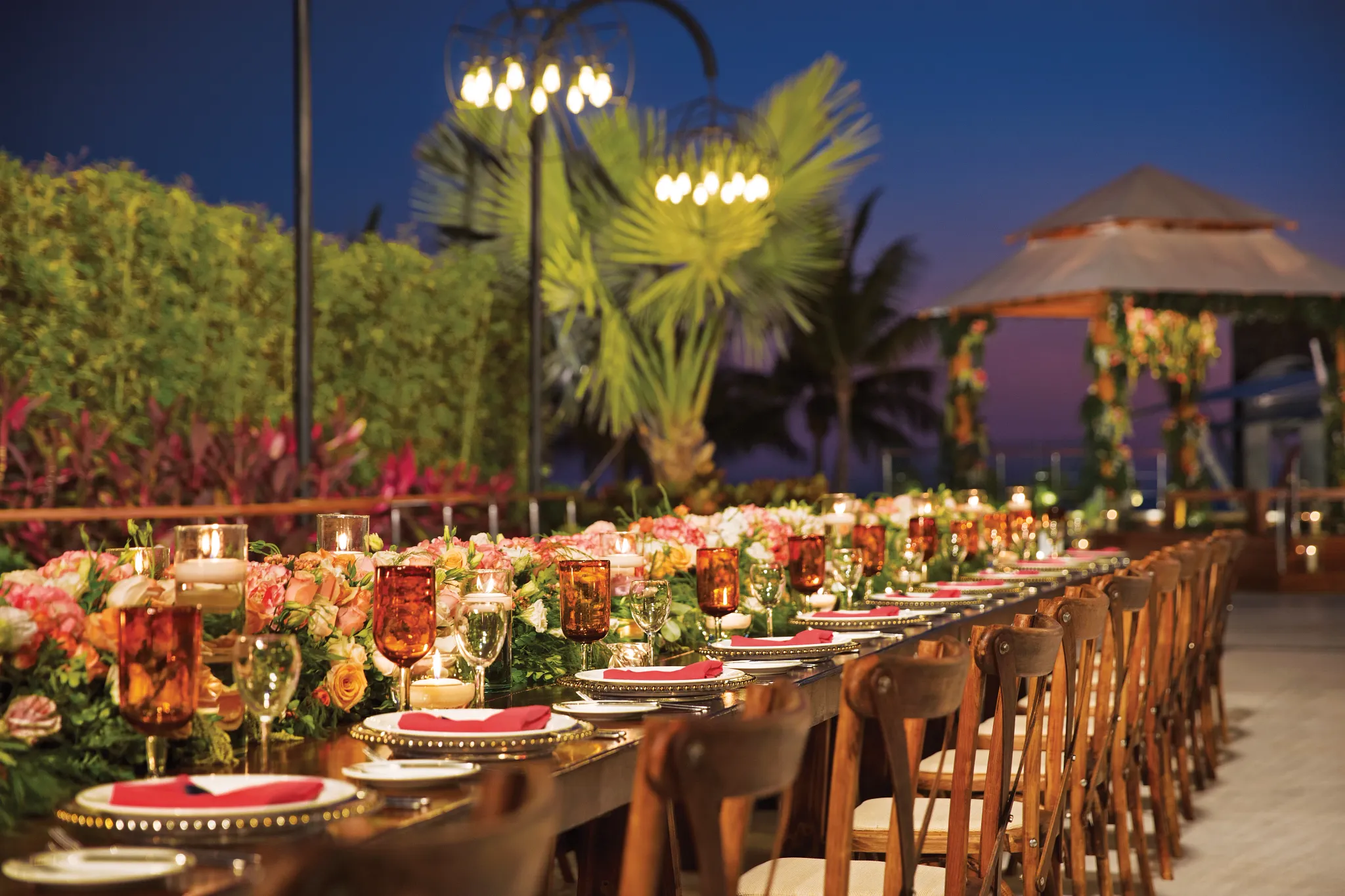Close-up of wedding table setting with candles, glassware, and floral décor at Secrets Vallarta Bay Puerto Vallarta