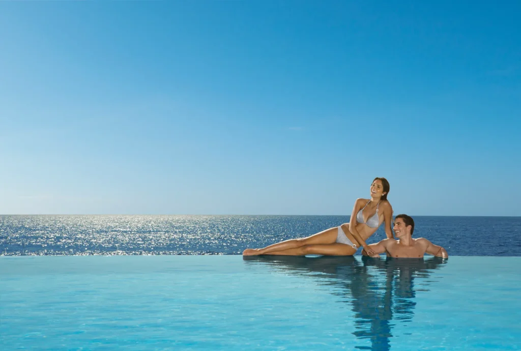 Couple relaxing in an infinity pool overlooking the ocean at Secrets Vallarta Bay Puerto Vallarta.