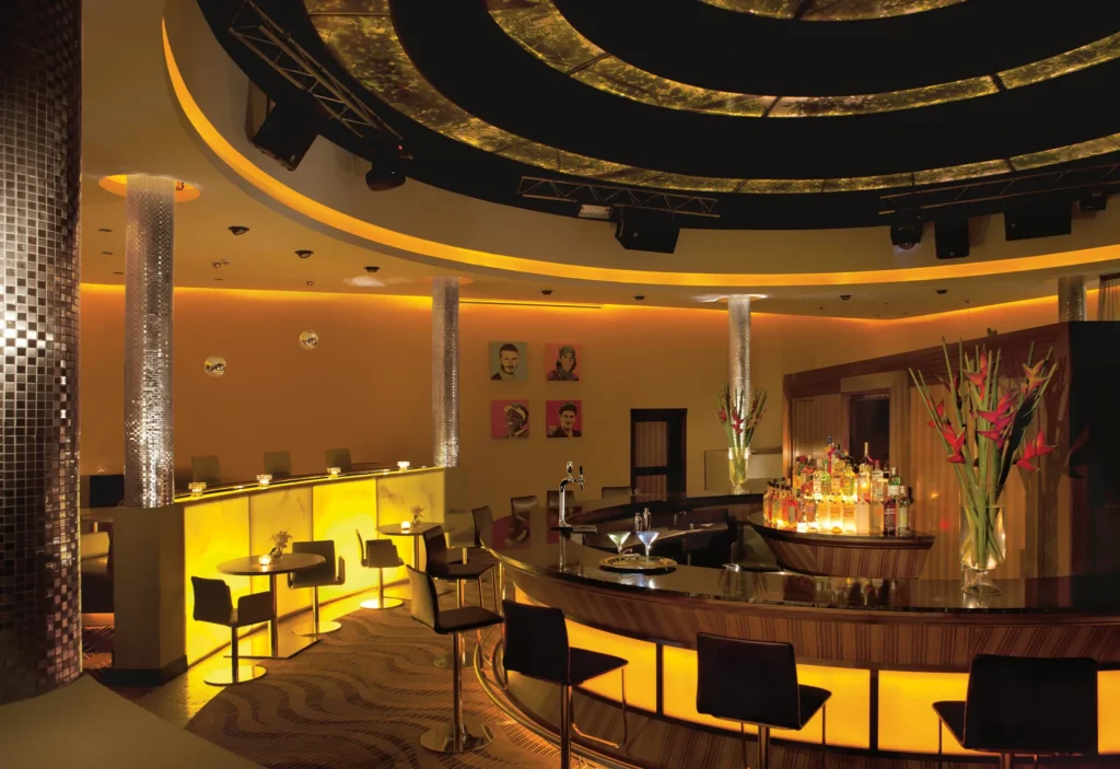Desires Music Lounge & Sports Bar at Secrets Wild Orchid Montego Bay featuring a stylish illuminated bar, lounge seating, and vibrant nightlife atmosphere.