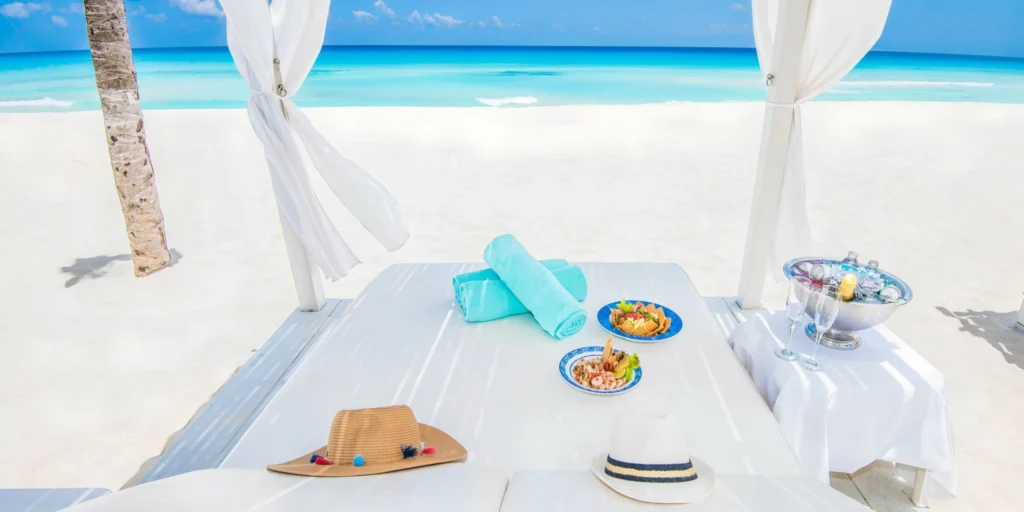 Luxury beachfront cabana setup with refreshments and ocean views at Sunscape Cancun Resort & Spa.