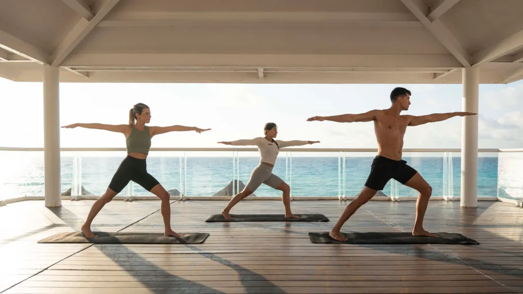 Guests practicing oceanfront yoga at Sunscape Cancun Resort & Spa with panoramic Caribbean Sea views.