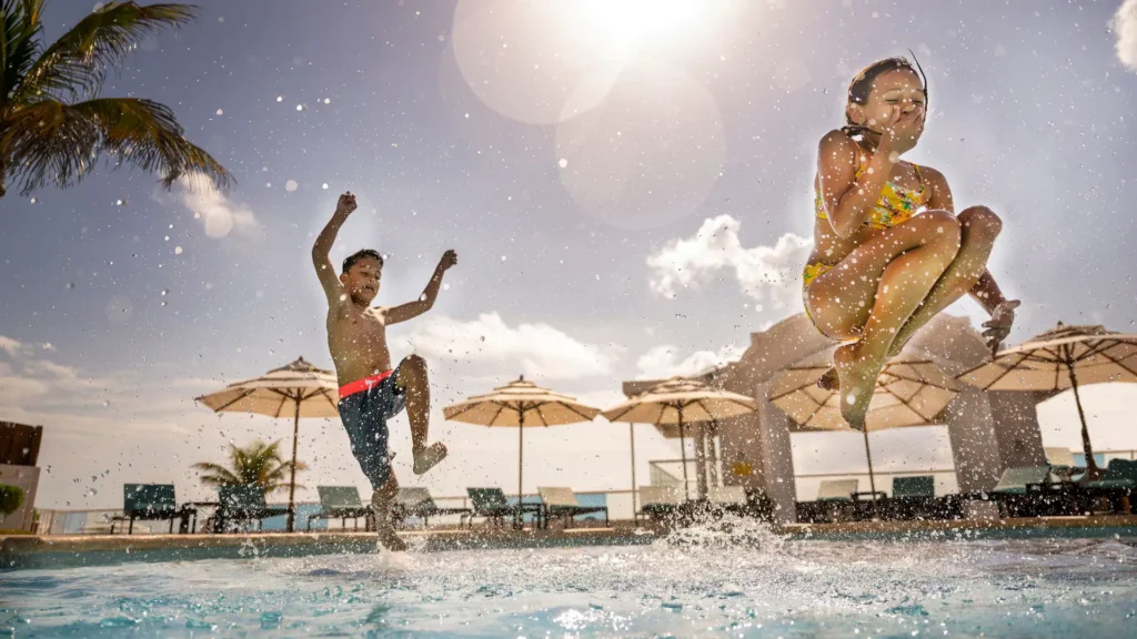 Children jumping into the pool at Sunscape Cancun Resort & Spa during a fun family vacation in Cancun.