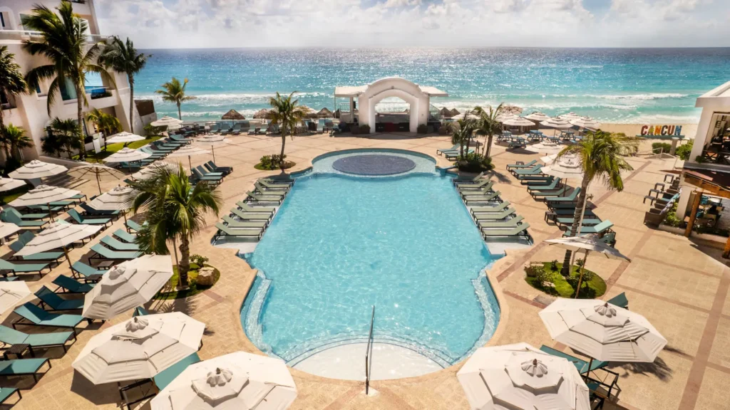 Elevated view of the beachfront pool and lounge umbrellas at Sunscape Cancun Resort & Spa in Cancun.