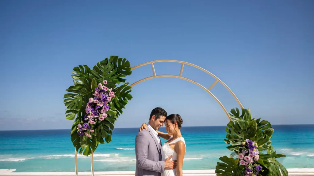 Couple embracing during a rooftop wedding ceremony overlooking the Caribbean Sea at Sunscape Cancun Resort & Spa.