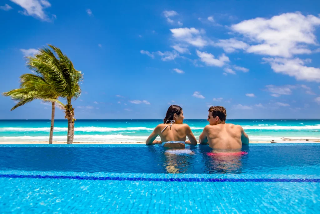 Couple relaxing in the infinity swim-up pool at Sunscape Cancun Resort & Spa beachfront suite.