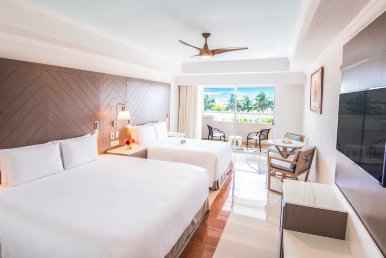 Junior Suite with two double beds and private furnished balcony at Sunscape Cancun Resort & Spa.