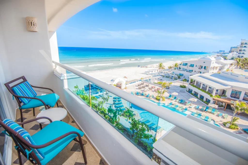 Junior Suite Ocean View balcony overlooking the beach and pools at Sunscape Cancun Resort & Spa.