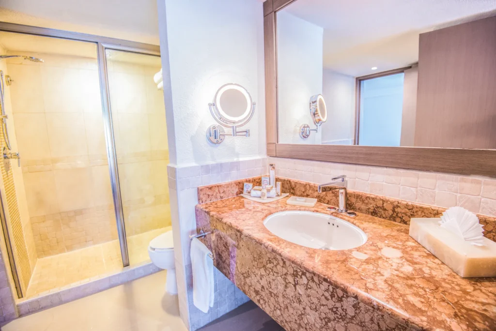 Junior Suite Ocean View bathroom with marble vanity and glass shower at Sunscape Cancun Resort & Spa.