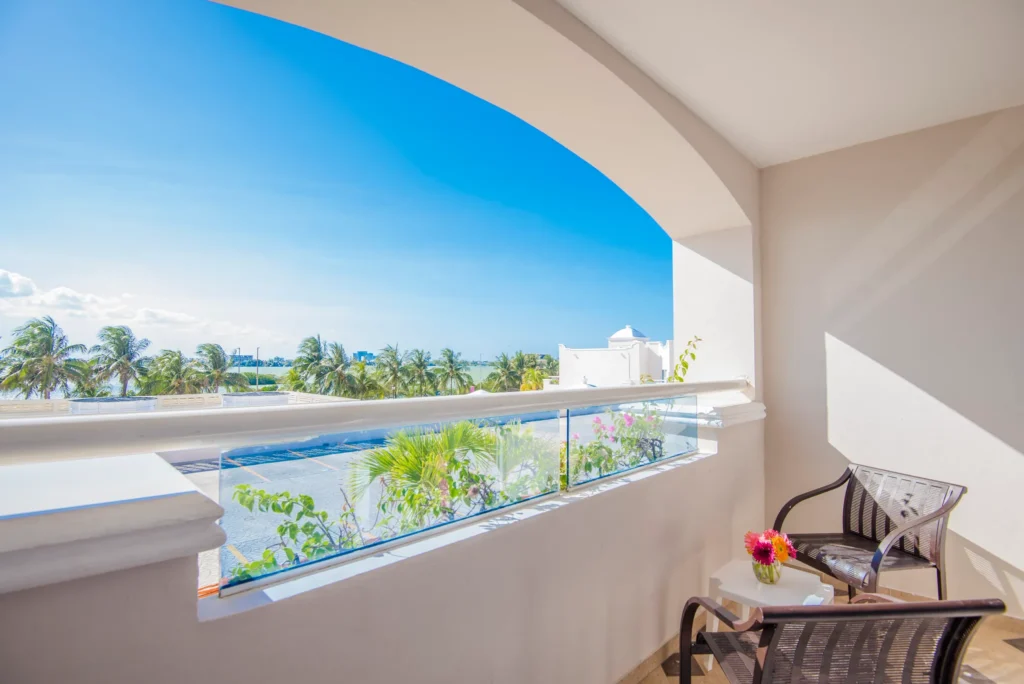 Private furnished balcony with tropical garden views at Sunscape Cancun Resort & Spa standard room.