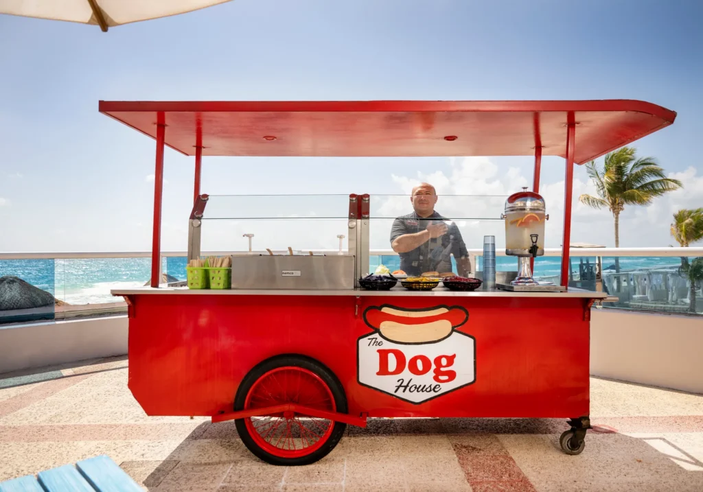 The Dog House at Sunscape Cancun Resort & Spa featuring gourmet hot dogs, casual outdoor seating, and a fun family-friendly atmosphere.
