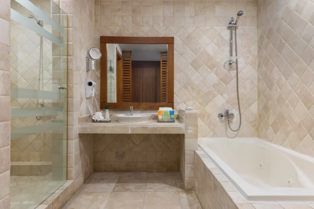 Deluxe Family Room bathroom with walk-in shower and soaking tub at Sunscape Coco Punta Cana.