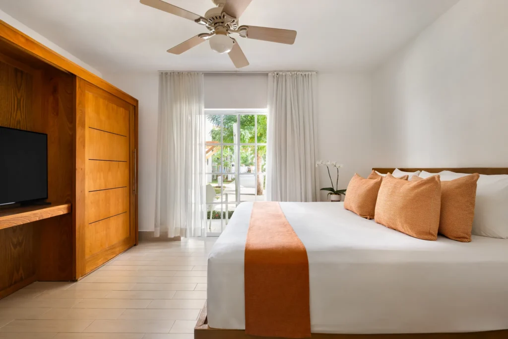 Sun Club 3-Bedroom Family Suite Tropical View king bedroom at Sunscape Coco Punta Cana with garden views.