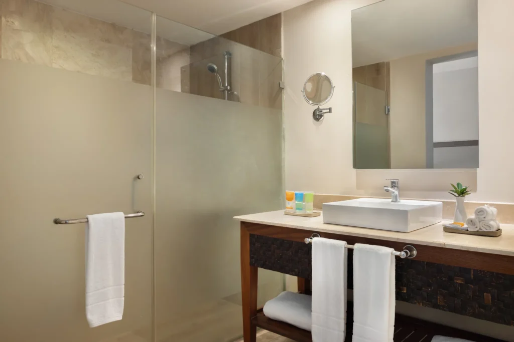 Sun Club Junior Suite Pool View bathroom with walk-in glass shower and modern vanity at Sunscape Coco Punta Cana.