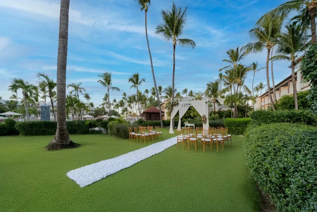 Elegant garden wedding ceremony setup surrounded by palm trees at Sunscape Coco Punta Cana Resort.