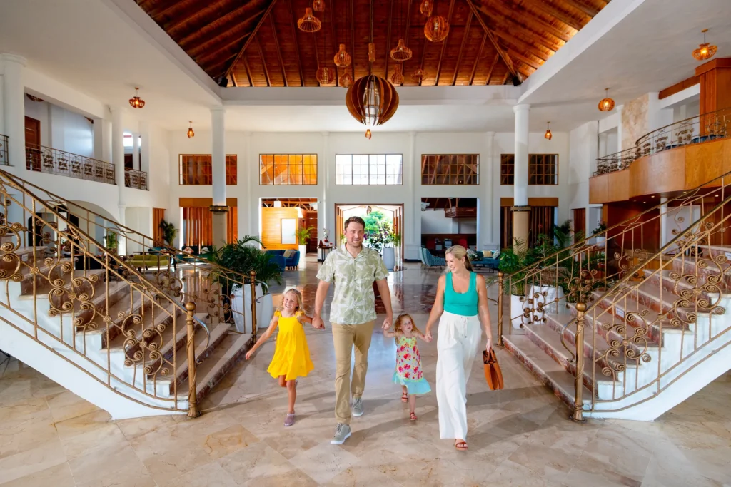 Family walking through the spacious lobby at Sunscape Coco Punta Cana Resort.